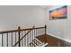 Stairway with wooden handrail and iron balusters, enhanced by an inviting beach-themed artwork at 3374 Grey St, Duluth, GA 30096