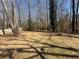 Large backyard bordered by mature trees and a wood fence at 5080 Springtree Ct, Lithonia, GA 30038
