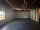 Spacious unfinished basement with painted floor and exposed ceiling at 5080 Springtree Ct, Lithonia, GA 30038