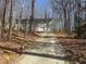 Two-story home with a long driveway leading to an attached two-car garage surrounded by trees at 5080 Springtree Ct, Lithonia, GA 30038