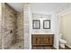 Bathroom featuring walk in tile shower, double sinks, and warm wood vanity at 428 Rainey Rd, Temple, GA 30179