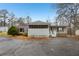 Inviting front exterior featuring a screened porch, stone accents, and ample parking space at 428 Rainey Rd, Temple, GA 30179