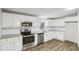 Bright kitchen featuring stainless steel appliances, white subway tile backsplash, and gray toned wood floors at 428 Rainey Rd, Temple, GA 30179