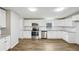 Bright kitchen featuring stainless steel appliances, white cabinets, and gray toned wood floors at 428 Rainey Rd, Temple, GA 30179