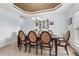 Elegant dining room featuring a dark wood table, six upholstered chairs, and a decorative tray ceiling at 4450 Sandalwood Way, Cumming, GA 30041