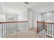 Upstairs hallway with a chandelier, decorative railing, and natural light at 4450 Sandalwood Way, Cumming, GA 30041