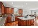 Open kitchen featuring stainless steel appliances, dark wood cabinets, and an island with gas cooktop at 4450 Sandalwood Way, Cumming, GA 30041