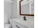 Updated half bathroom with stylish vanity, marble countertop, modern faucet, and framed mirror at 11 Newport Nw Pl, Atlanta, GA 30318