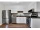 Well-lit kitchen with stainless steel appliances, granite countertops, and white cabinets at 11 Newport Nw Pl, Atlanta, GA 30318