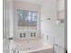 Bathroom featuring a soaking tub, a window and white cabinets and trim at 110 Oak Wood Ln, Covington, GA 30016