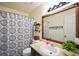 Well-lit bathroom with decorative shower curtain, a large framed mirror, and a stylish vanity at 2096 Old Jackson Rd, Locust Grove, GA 30248