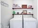 Bright laundry room with shiplap wall, floating shelves, and modern washer and dryer units at 2096 Old Jackson Rd, Locust Grove, GA 30248