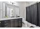 Modern bathroom featuring dark cabinets, white countertops, and a shower with a stylish dark shower curtain at 2300 Peachford Rd # 1410, Atlanta, GA 30338