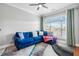 Bright living room featuring a comfortable blue couch, large window and ceiling fan at 2300 Peachford Rd # 1410, Atlanta, GA 30338