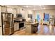 Bright kitchen featuring gray cabinets, stainless steel appliances, and an island with barstool seating at 11700 Brightside Pkwy, Hampton, GA 30228