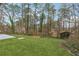 View of backyard with green grass and trees under a blue sky with some backyard structures at 5368 Stafford Nw Dr, Lilburn, GA 30047