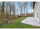 View of backyard with green grass, trees, concrete patio, and gray siding home at 5368 Stafford Nw Dr, Lilburn, GA 30047