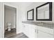 Bathroom featuring double sinks with granite vanity tops, black framed mirrors, and new flooring at 5368 Stafford Nw Dr, Lilburn, GA 30047