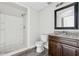 View of bathroom featuring white shower and granite countertop with a dark wood vanity at 5368 Stafford Nw Dr, Lilburn, GA 30047