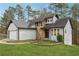 Charming home with stone accents, landscaped yard, and attached two-car garage at 5368 Stafford Nw Dr, Lilburn, GA 30047