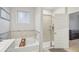 Bright bathroom featuring a soaking tub with stone accents and a glass-enclosed shower at 938 Blue Juniper Cir, Loganville, GA 30052