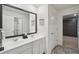 Bright bathroom featuring double sinks, a large mirror, and white cabinetry at 938 Blue Juniper Cir, Loganville, GA 30052