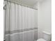Clean, minimalist bathroom featuring a white and grey striped shower curtain at 938 Blue Juniper Cir, Loganville, GA 30052