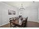 Elegant dining room featuring a large wooden table with seating for eight and a modern chandelier at 938 Blue Juniper Cir, Loganville, GA 30052
