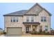Beautiful two-story home featuring stone accents, brick, a covered porch, and an attached two-car garage at 938 Blue Juniper Cir, Loganville, GA 30052