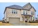 Attractive two-story home with a brick facade, attached garage, and welcoming front porch at 938 Blue Juniper Cir, Loganville, GA 30052