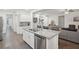 Open kitchen concept with granite counters and island seating flowing into the living area at 938 Blue Juniper Cir, Loganville, GA 30052