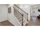 Carpeted staircase with dark wood banister leads to upper level, adjacent to entryway and hallway at 938 Blue Juniper Cir, Loganville, GA 30052