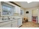 A kitchen featuring white cabinets, tile floor, stainless sink and dishwasher, and a wooden table set at 2612 Arlene Ne Way, Atlanta, GA 30305