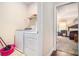 Laundry room area with white washer and dryer and shelving for storage at 2656 Muskeg Sw Ct, Atlanta, GA 30331