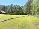 Expansive backyard featuring green grass, mature trees, and stone edging at 4267 Klondike Rd, Lithonia, GA 30038