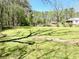 The vast backyard is a grassy expanse with buildings in the distance and some wooded area at 4267 Klondike Rd, Lithonia, GA 30038