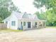 Charming white farmhouse with a metal roof, inviting front porch with string lights at 4267 Klondike Rd, Lithonia, GA 30038