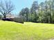 Large grassy backyard with a fence, mature trees, and a detached garage at 4267 Klondike Rd, Lithonia, GA 30038