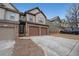 Street view of townhome featuring neutral siding, brick accents, and two car garage at 1211 Grampian Pass # 15, Marietta, GA 30008