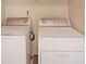A laundry room showcasing white, front-loading washer and dryer appliances at 1211 Grampian Pass # 15, Marietta, GA 30008