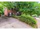 Side view of brick home with lush trees, a long driveway, and manicured front yard at 830 Barnett Ne St # 8, Atlanta, GA 30306