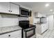 Close-up view of stainless steel range and microwave with white cabinets and stone counter at 830 Barnett Ne St # 8, Atlanta, GA 30306