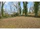 Large backyard area surrounded by mature trees and a wooden fence for privacy at 214 Maple St, Atlanta, GA 30354