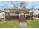 Charming home featuring a covered porch, wooden deck, and mature landscaping at 214 Maple St, Atlanta, GA 30354