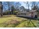 Large grassy backyard with a one-story house featuring a wall of windows and a red door at 382 Golfview Nw Rd, Atlanta, GA 30309