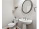 This bathroom features a white toilet and pedestal sink with a modern oval mirror and stylish decor at 2959 Rivergreen Se Ln, Atlanta, GA 30339