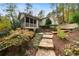 Backyard view of house with screened in porch, stone stairs, terraced landscaping and lush garden at 5525 Whitner Dr, Sandy Springs, GA 30327