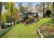 A spacious backyard with a screened porch, stone retaining walls, and lush greenery at 5525 Whitner Dr, Sandy Springs, GA 30327