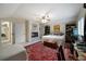 Spacious bedroom featuring a fireplace, ceiling fan, and a comfortable bed with a patterned rug at 5525 Whitner Dr, Sandy Springs, GA 30327