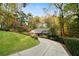 Long driveway leading to a one-story home surrounded by mature trees and lush landscaping at 5525 Whitner Dr, Sandy Springs, GA 30327